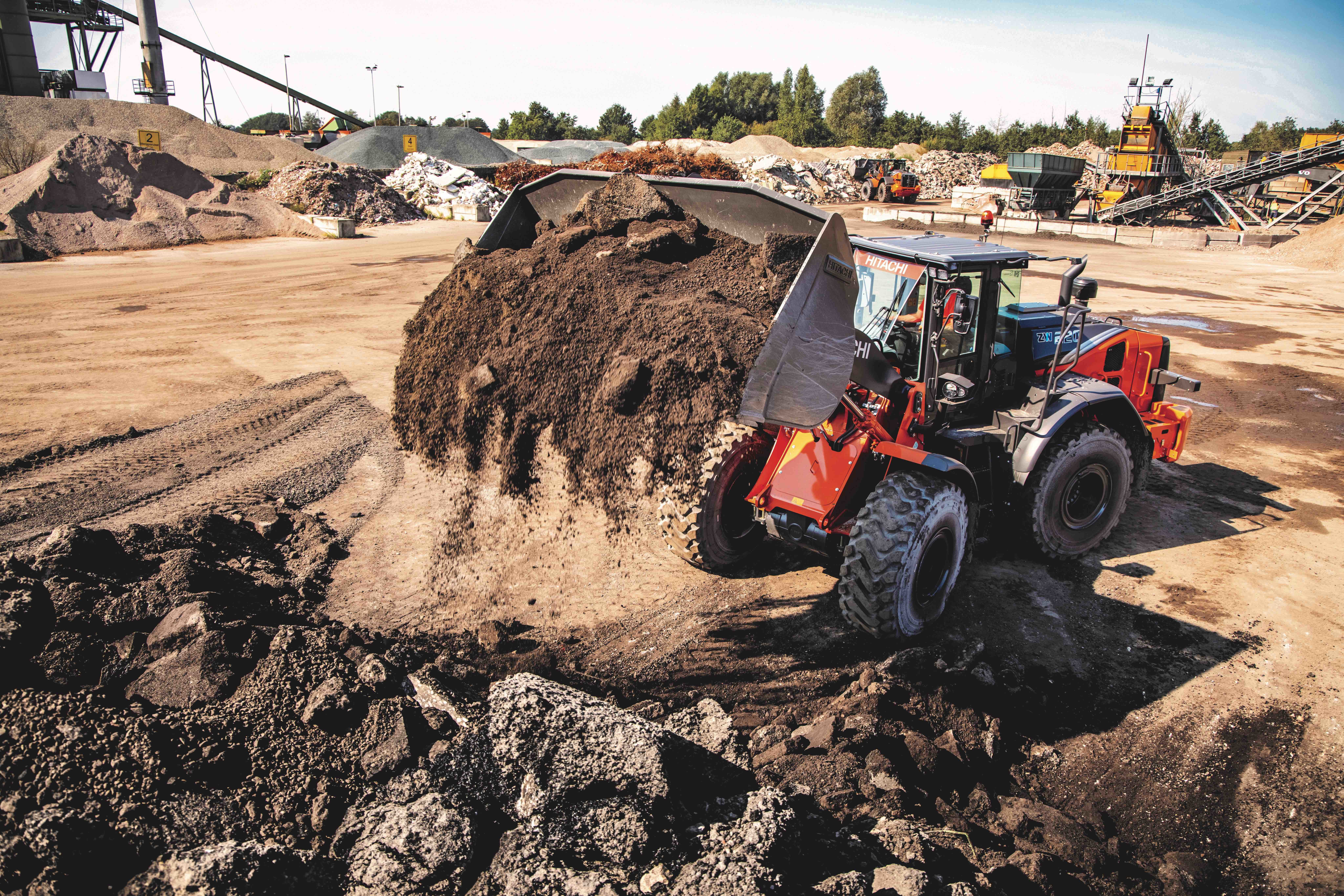 Hitachi ZW220 wheel loader dumps dirt