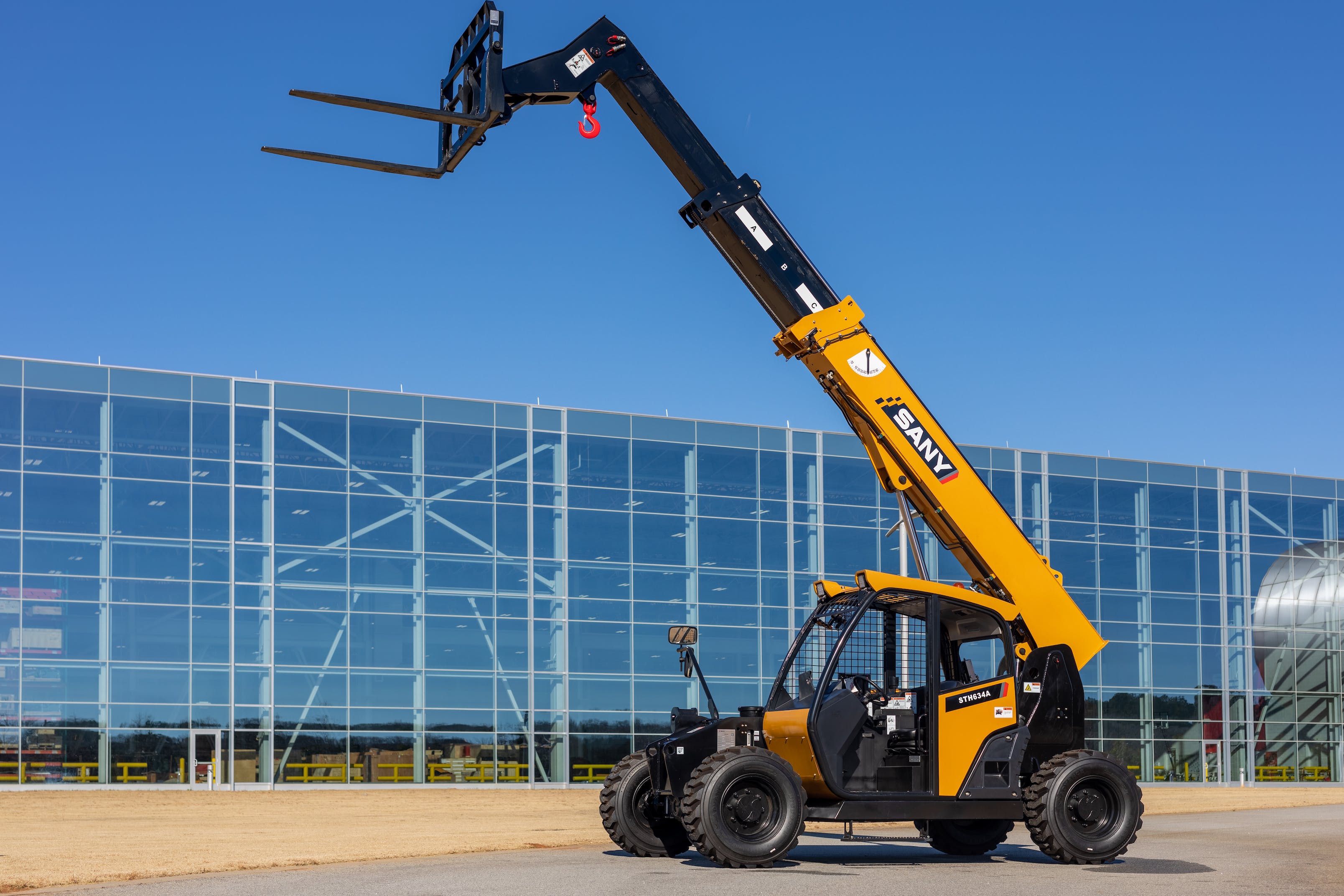 Sany STH634A Telehandler boom extended in front of glass building